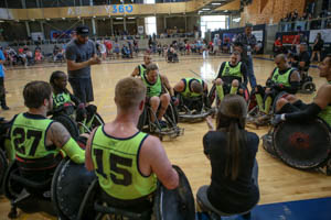 Scott Hogsett sits with his team, all sporting neon green jerseys.